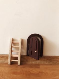 a small wooden ladder next to an open door on the floor near a miniature chair