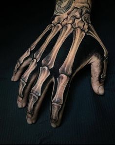 a person's hand with a skeleton tattoo on it