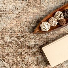 a wooden boat filled with balls sitting on top of a carpeted floor next to a box