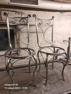 two metal chairs sitting next to each other