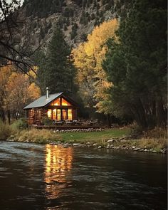 a small cabin sitting on the side of a river