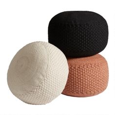 three different colored knitted poufles sitting next to each other