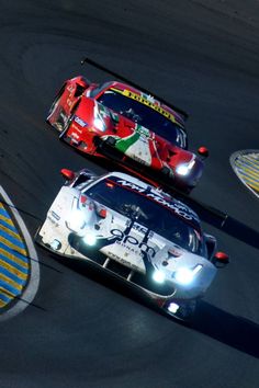 two racing cars driving on a race track