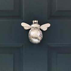 a close up of a door with a metal bee on it