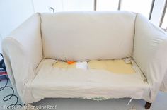 the couch is covered with white fabric and has been placed on it's side