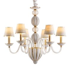 a white chandelier with six lights and shades on the bottom half of it