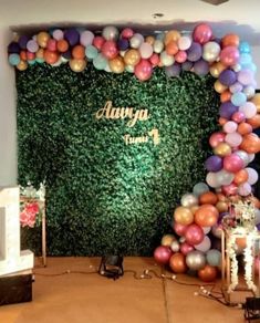 balloons and greenery decorate the backdrop for an event