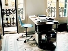 a room with a desk, chair and window on the floor in front of it