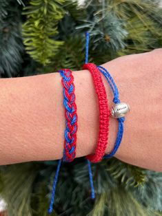 a woman's arm with two bracelets on it, one is red and the other is blue