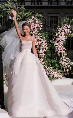 a bride and groom posing for a photo in front of pink flowers on the steps