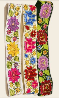 three different colored ribbons with flowers on them