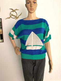 "This vintage sweater is the cutest, and it is so soft and cozy! This is a 1980's nautical sweater by Catalina. It has blue and green stripes and a sailboat on the front. The knit for the sailboat and sleeves is super cute with a little see through-ness happening. It has a slouchy, cozy vibe. It is in excellent vintage condition and a size Medium. Measurements laid flat: Arm pit to arm pit: 22\" Length: 23: Vintage items are sold \"as is\" and no returns. Please ask any questions before purchasing. LOVE THIS! Follow us on Tik Tok @ https://www.tiktok.com/@sauceboxvintage" Nautical Cotton Sweater With Crew Neck, Nautical Cotton Crew Neck Sweater, Nautical Sweater, Short Sleeve Sweater, Vintage Sweater, Pullover Sweater Women, Short Sleeved Sweaters, Vintage Sweaters, Green Stripes