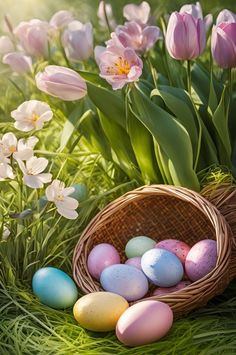 a basket filled with eggs sitting on top of green grass next to pink and white flowers