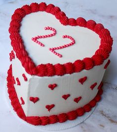 a heart shaped cake with red and white icing