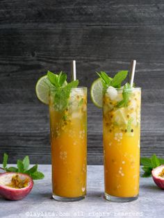 two glasses filled with orange juice and garnished with mint