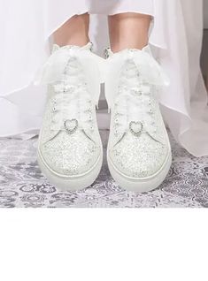 a person wearing white shoes with bows on them