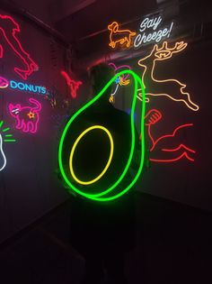 a neon sign in the shape of an avocado is lit up by neon lights