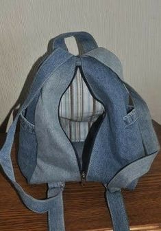 a denim purse sitting on top of a wooden table