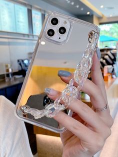 a woman is holding up her phone case with clear beads on the front and sides