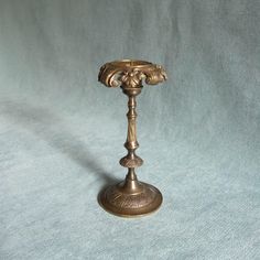 an antique brass candle holder on a blue background