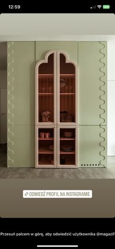 the interior of a room with green walls and white furniture, including an arched glass door