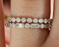 a woman's hand with a diamond ring on her left and an engagement band on her right