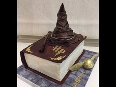 a cake made to look like a book with a wizard's hat on top