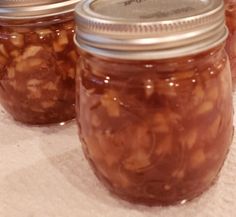 three jars filled with food sitting on top of a table