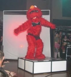 a large red stuffed animal standing on top of a white box