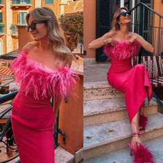 a woman in a pink dress sitting on some steps