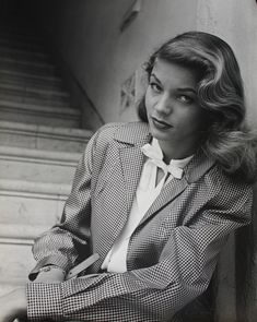 a woman in a suit sitting on the steps