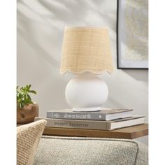 a white table lamp sitting on top of two books