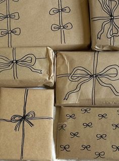 several wrapped presents with bows on them sitting on top of each other in brown paper