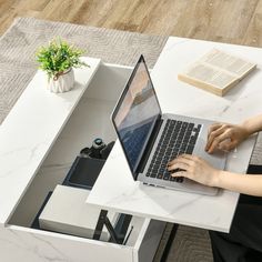 a woman sitting at a table using a laptop computer