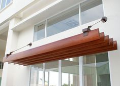 an outside view of a building with sliding glass doors and wood slats on it