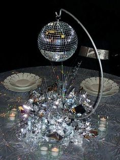 a disco ball sitting on top of a table next to plates and silverwares