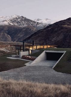 the house is surrounded by mountains and grass