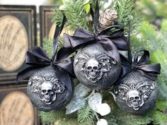 an ornament hanging from a christmas tree decorated with skulls and bowknots