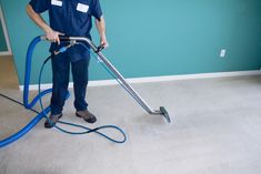 a man is cleaning the floor with a vacuum