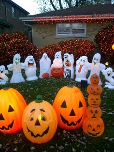 halloween pumpkins and ghost statues in front of a house