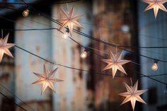 star shaped string lights hanging from wires outside