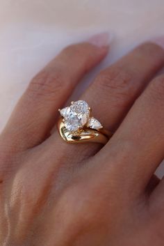 a woman's hand with a ring on it and a diamond in the middle