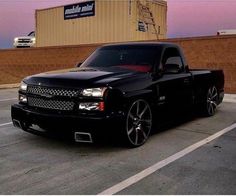 a black truck parked in front of a building