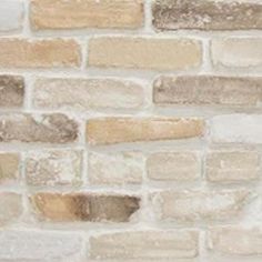 a white brick wall with brown and tan bricks