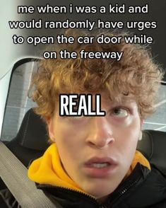 a young man with curly hair sitting in the back seat of a car