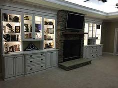 a living room filled with furniture and a flat screen tv on top of a fireplace