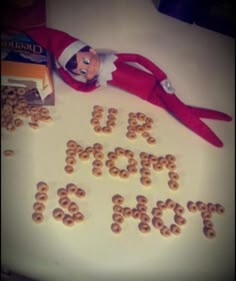 an elf laying on top of a table with cereal spelled out in the shape of letters