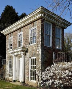 an old brick house with white trim and windows