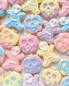 there are many decorated cookies with skulls and bones on the top one is pink, blue, yellow and white