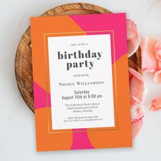 an orange and pink birthday party card sitting on top of a wooden plate next to flowers